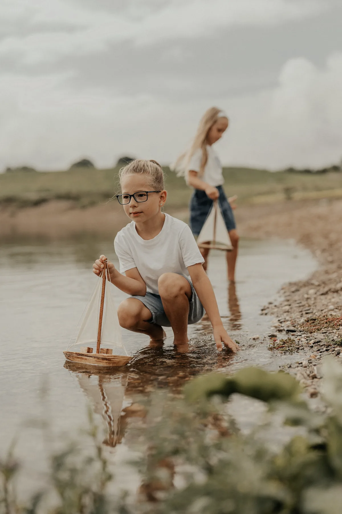 Kinder mit Segelbooten am See